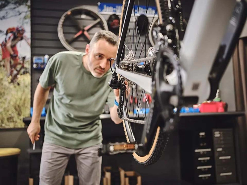 Ein Fachhändler blickt auf ein Hinterrad